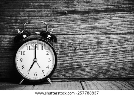 Retro alarm clock with wood wall background, Black and white tone