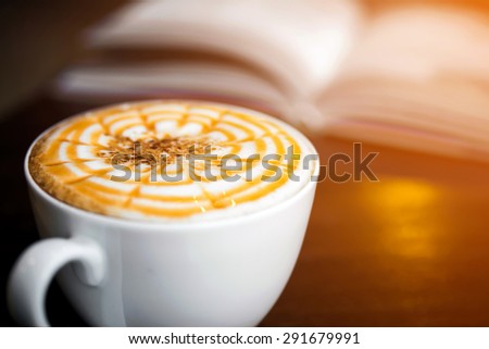 Cup of cappuccino coffee with blur book background