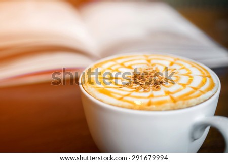 Cup of cappuccino coffee with blur book background