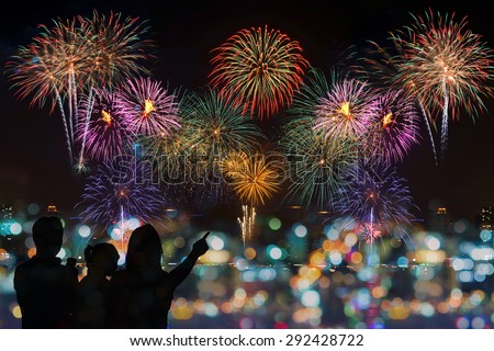 The happy family looks celebration fireworks on the night sky
