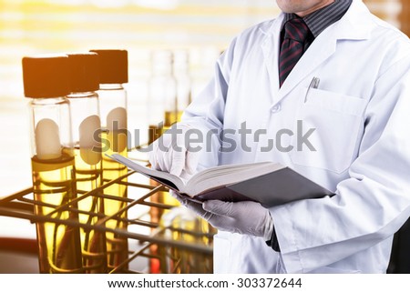 Doctor reading text book with test tubes background