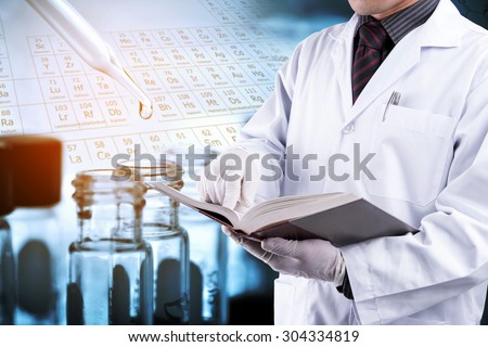 Doctor reading text book with blur test tubes background, laboratory concept