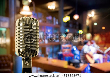 Retro microphone against blur colorful light in pub and restaurant background