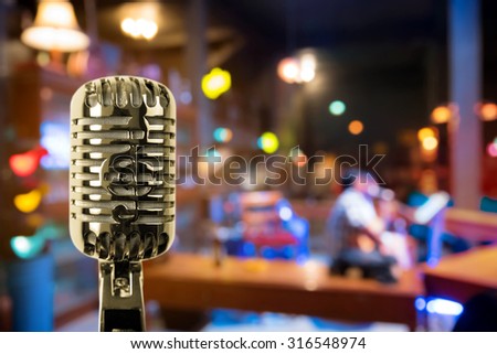 Retro microphone against blur colorful light in pub and restaurant background