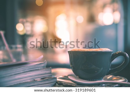 Cup of cappuccino in the coffee shop with magazine, vintage tone