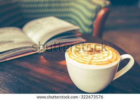 vintage picture of cappuccino coffee with book, vintage tone