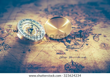 Retro compass on ancient world map, dark vintage style