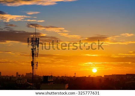 Silhouette of mobile communication antennas in an orange sunset