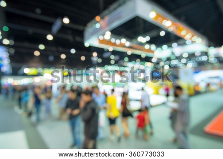 Abstract blurred image of people in cars exhibition show