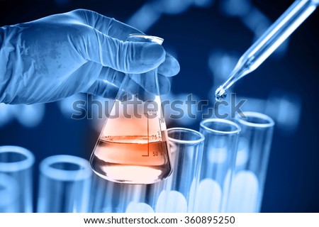 Flask in scientist hand with test tubes