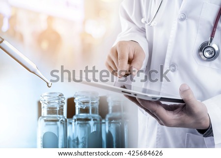 Doctor using tablet with teat tube in rack, medical concept