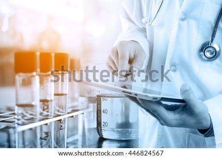 Doctor using tablet with teat tube in rack, medical research and development concept