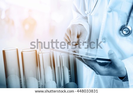 Doctor using tablet with test tubes in rack, medical research and development concept