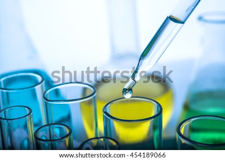 Dropping chemical liquid to test tube, laboratory research and development concept