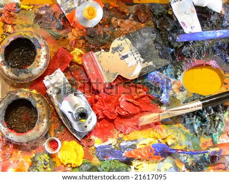 Close up of an artist's palette with many colors, colors tubes and brushes