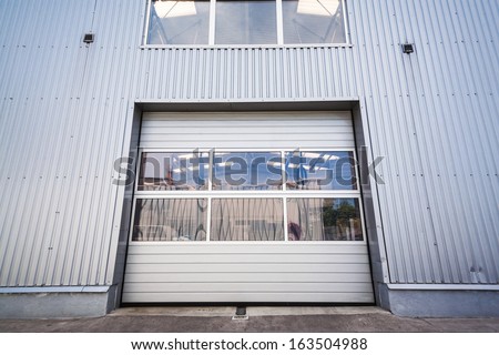 Sliding door with window of an industrial white hall