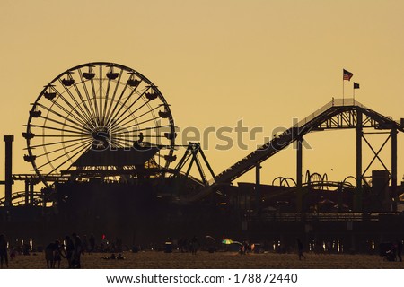 LOS ANGELES, CA - MAY 27, 2013: Silhouette of Pacific Park with roller coaster and ferris wheel against the evening sky at dusk
