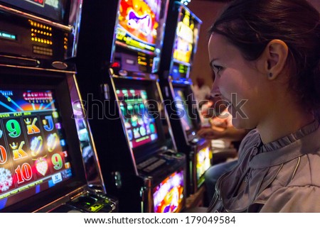 LAS VEGAS - JULY 13, 2013: Concentrated girl playing slot machines in The Quad Resort and Casino.