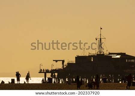 Santa Monica, Los Angeles, CA, USA - 26th May 2013: Silhouettes of people walking at Santa Monica pier at sunset.
