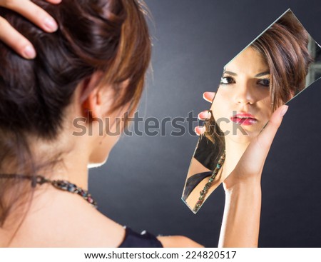 Beautiful brunette watching herself in the mirror