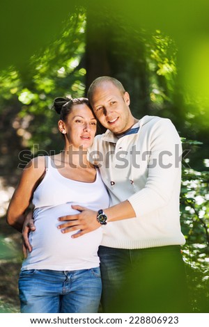 A husband and his pregnant wife holding each other