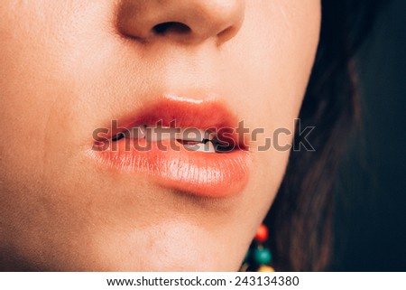 Closeup of a woman biting her red lip