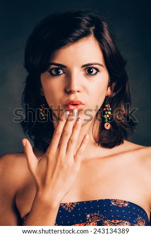 Portrait of a surprised young  woman - isolated on black.