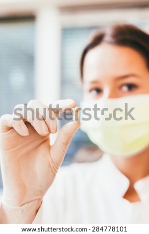 Gloved hand of dentist holding extracted  tooth