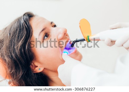 Female patient receiving dental filling drying procedure.