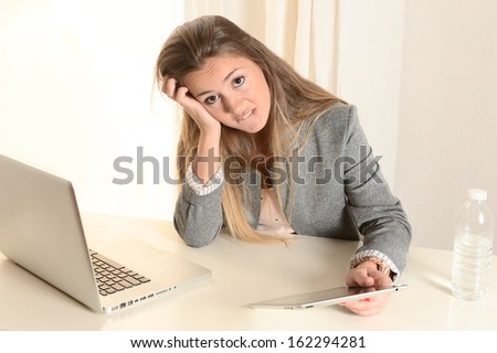 Young stressed Business Woman with laptop and tablet  frustrated at work
