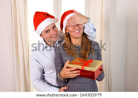 Romantic Young man giving christmas present surprise to happy woman