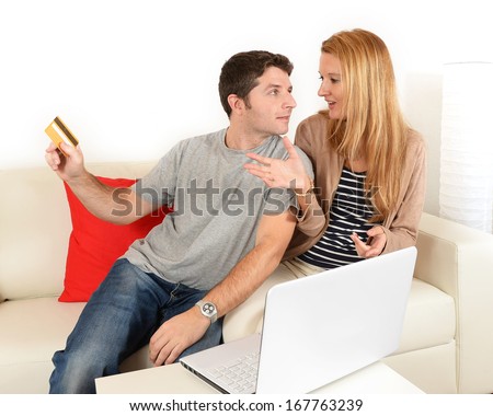Man taking credit card off his wife when she is internet shopping