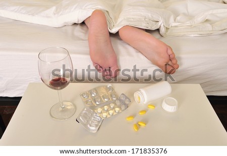 Feet on bed of sleeping man suffering hangover and headache after party with wine