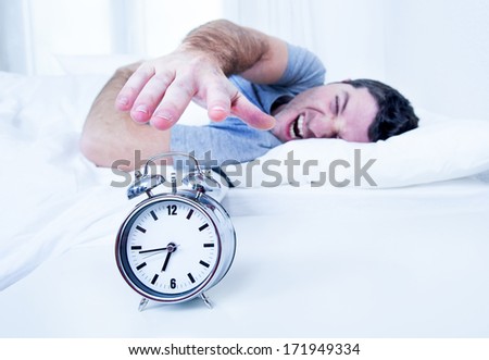 sleeping man disturbed by alarm clock early morning