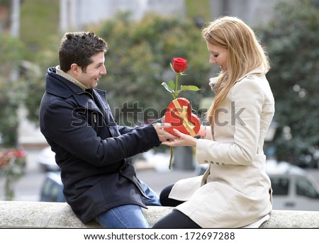 Romantic Man giving flower and heart shaped box to woman for valentines day