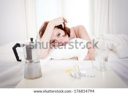 red hair girl hungover wanting coffee and medication to help with her hungover in bed