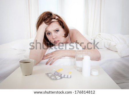 red hair girl hungover wanting coffee and medication to help with her hungover in bed