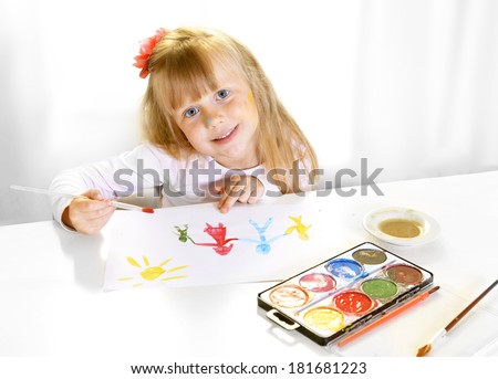 Cute artistic little blonde girl painting and drawing family in colors