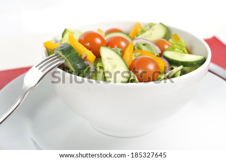 diet written with vegetables on a plate on red dish mat with fork and knife in healthy nutrition and dieting resolution concept