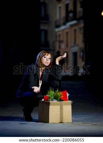 young attractive jobless business woman depressed and fired from work with cardboard box office belongings wasted on street after loosing her job, worried and sad