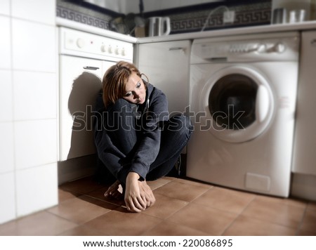 lonely depressed and sick woman sitting alone on kitchen floor in stress , depression and sadness feeling miserable in barefoot looking desperate