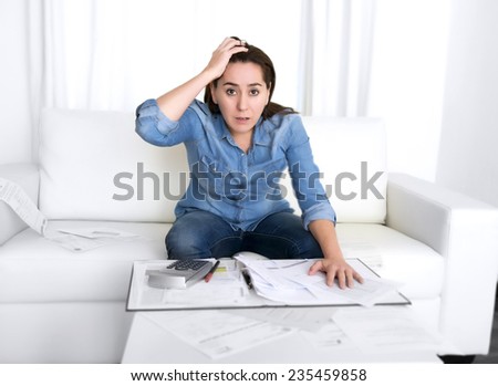 young woman worried at home in stress at living room accounting debt bills expenses with calculator feeling desperate on payments in bad financial situation concept