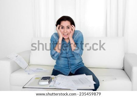 young woman worried at home in stress at living room accounting debt bills expenses with calculator feeling desperate on payments in bad financial situation concept