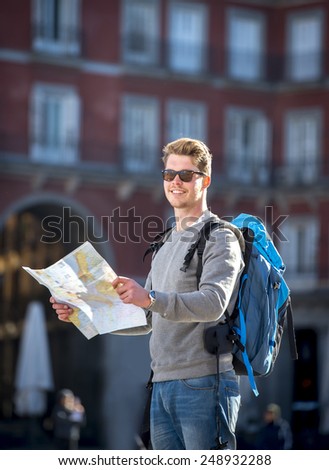 young attractive student backpacker tourist in Europe looking city map outdoors enjoying holidays travel destination in tourism and urban exploring concept