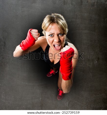 young attractive and sexy girl training boxing with wraps on fists feeling angry in female boxer and fighting woman concept isolated on black background