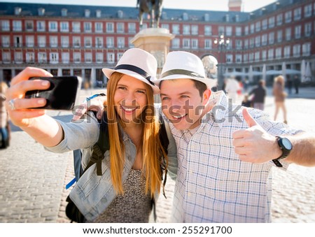 young beautiful friends tourist couple visiting Europe in holidays exchange students and taking selfie picture together in town smiling happy on sunny day in travel and vacation concept