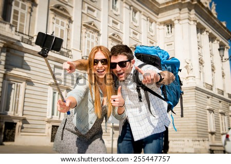 young beautiful friends tourist couple visiting Spain in holidays exchange students and taking selfie stick picture together in town happy on sunny day in travel and vacation concept