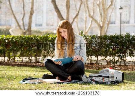 young beautiful student girl lying on campus park grass with books on rug studying happy preparing exam in university and college education concept