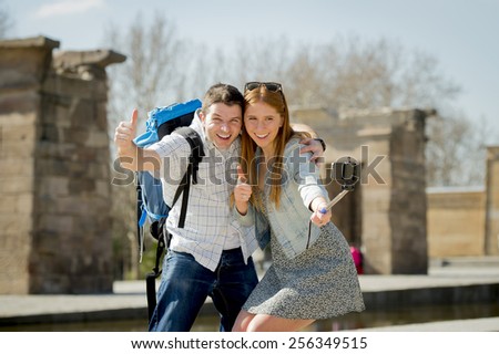 young American student and tourist couple visiting Egyptian monument taking selfie photo with stick carrying expedition backpack in holiday tourism and vacation travel concept