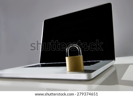locked lock on keyboard of computer laptop with blank black screen as copy space for warning message about danger of vulnerable system and data in cyber crime and hacker attack concept